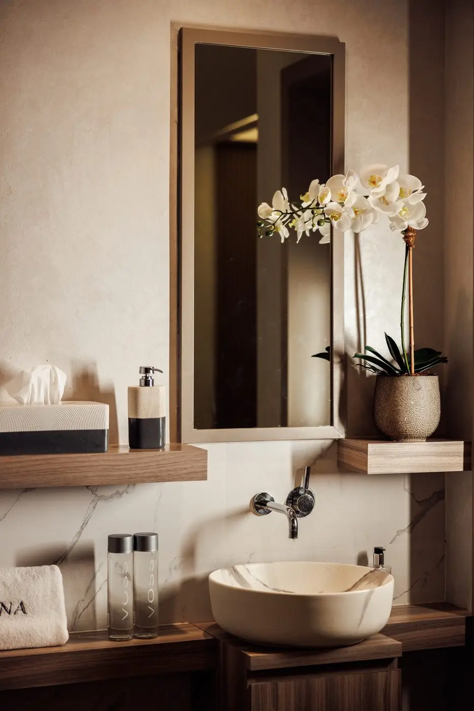 Washbasin, mirror and orchids in the treatment room bathroom at the DIFC branch
