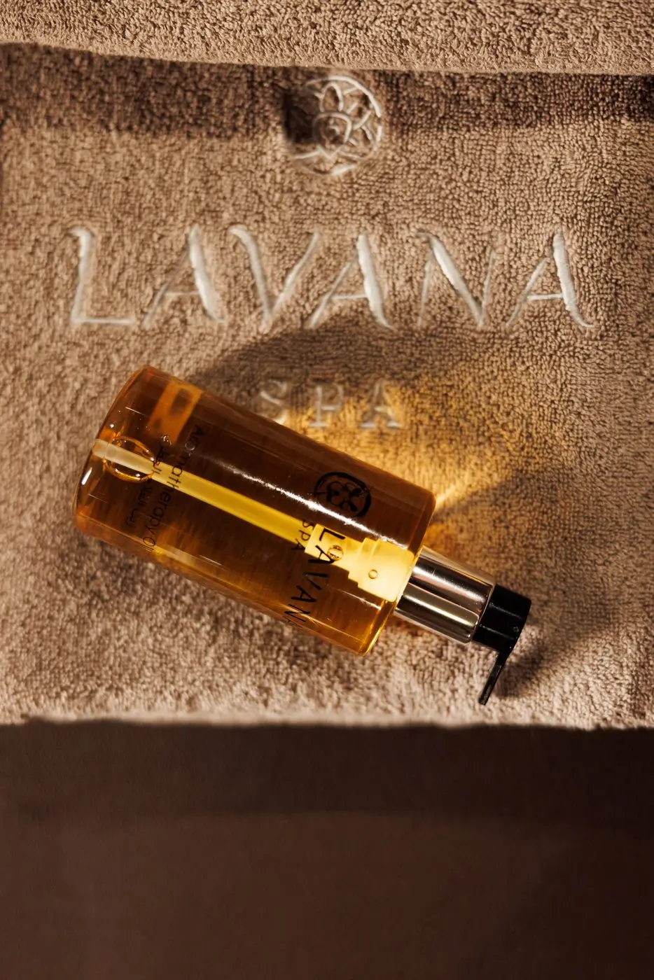 Bottle of massage oil resting on a Lavana towel at the Bur Dubai branch