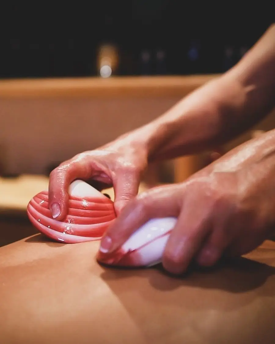 Close-up of a heated lava shell being worked along the back at Lavana Spa