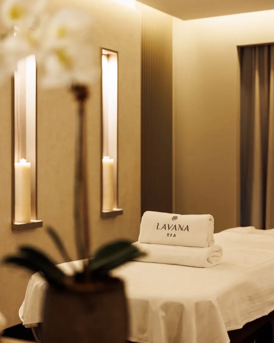 A treatment bed with folded Lavana Spa towels and candle niches at Lavana Spa DIFC