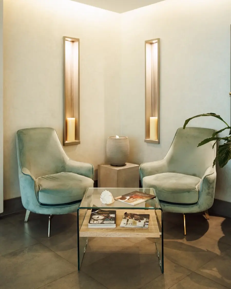 Two armchairs and a glass table in the waiting lounge at Lavana Spa DIFC