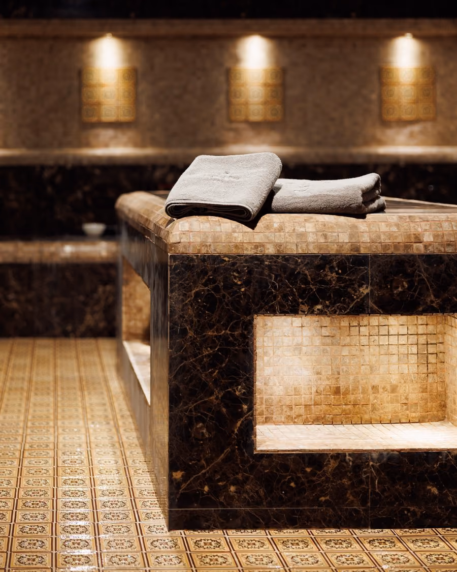 Heated marble hammam table with folded towels in the Moroccan Bath room at Lavana Spa