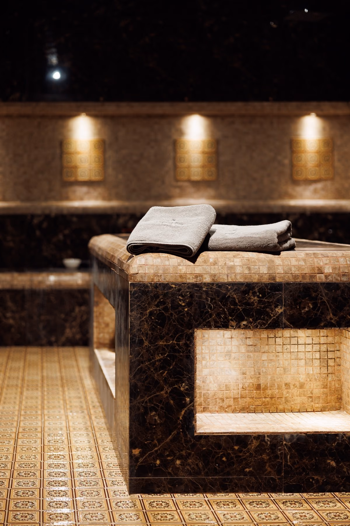 Heated marble hammam table with folded towels in the Moroccan Bath room at Lavana Spa