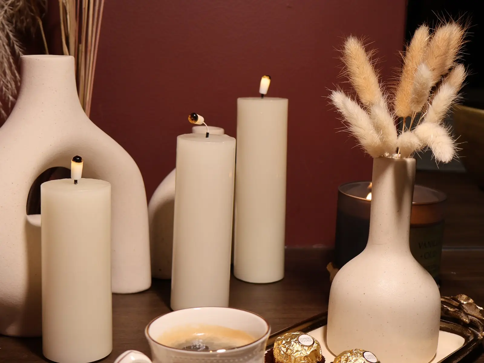 Lit pillar candles, a cup of tea and dried grasses on a tray in the Lavana Spa lounge